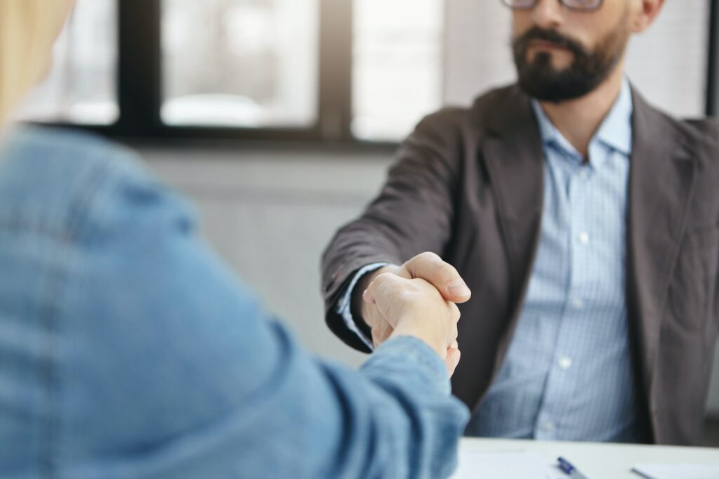 Business partneship concept. Successful businesspeople shake hands after signed contract, have agree