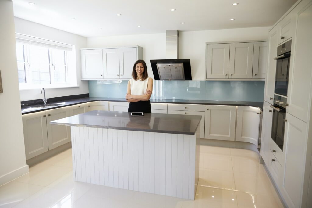 Portrait Of Female Realtor In Kitchen Valuing House